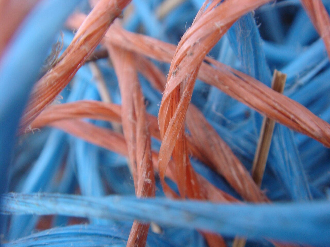 Close-up of blue and red polypropylene baler twine strands showing the fibrillated split-film texture