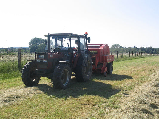 A Case IH 840 tractor coupled to a Welger round baler — representative of the Case IH baling rigs (RB455, RB465, RB564, RB565, RBX561, RBX562) where cornstalk-tear and wrap-error faults most commonly appear.