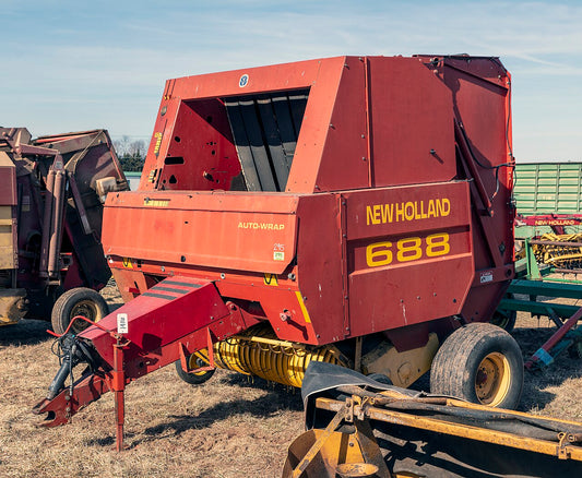New Holland 688 round baler with Auto-Wrap dispenser — when a baler will not stop wrapping, the cause is usually the wrap-count sensor, a setting, a stuck relay, low voltage, or an uncut knife.