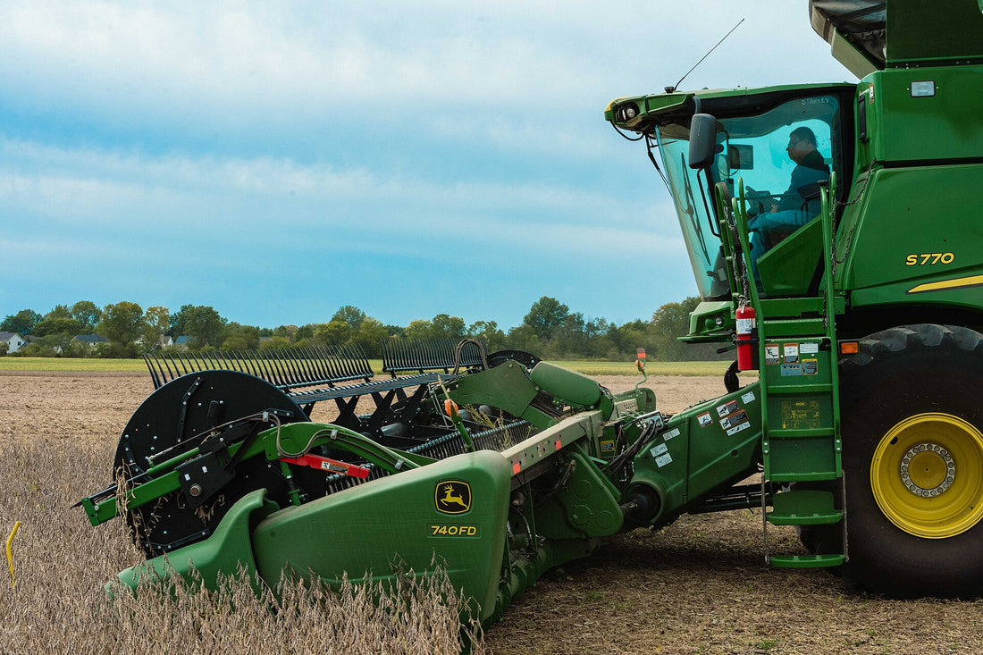 A combine harvesting soybeans — the bean straw left behind becomes cheap roughage and bedding once it is baled.