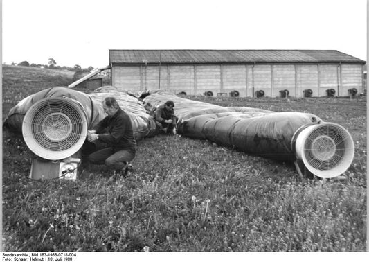 Black-and-white photograph of large fans and air-collection ducts outside a hay-drying barn in Streufdorf in 1988.