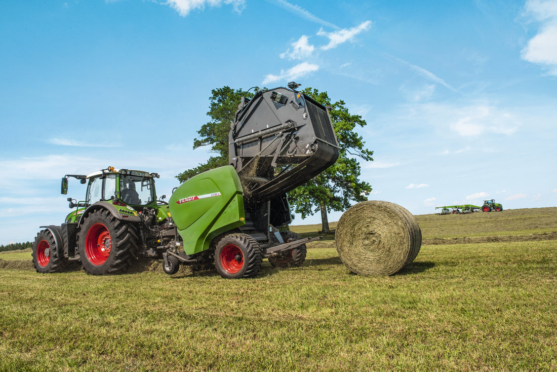Variable-chamber round baler discharging a finished round bale with the tailgate raised, the point in the cycle where density pressure should drop back toward zero