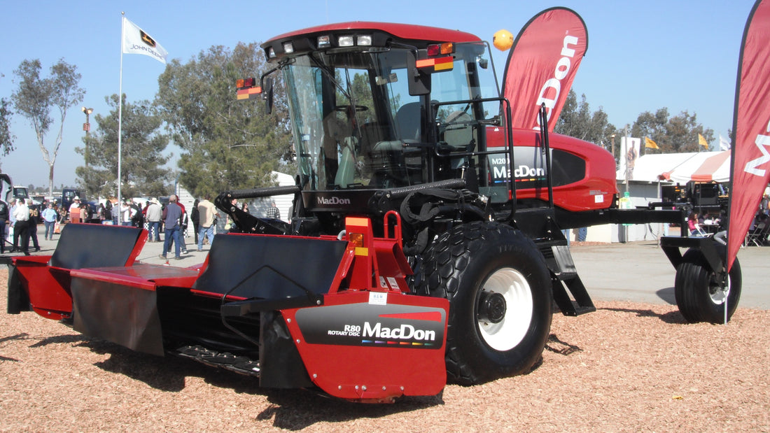 A MacDon M200 self-propelled windrower fitted with an R80 rotary disc header for cutting hay